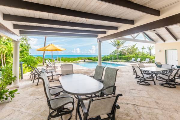 Covered poolside patio facing beach at Serenity House Turks and Caicos